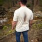 Man standing in forest wearing pheasant t-shirt.